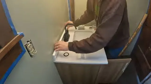 Technician working at a stainless utility sink and faucet during plumbing service in Bell West Ranch, Surprise, AZ