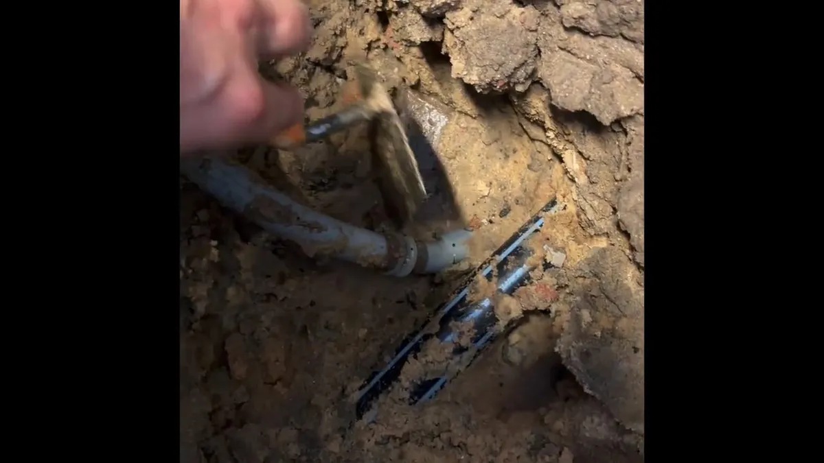 Buried plumbing pipe exposed in soil with blue repair couplings visible during plumbing service in Surprise Farms, Surprise, AZ