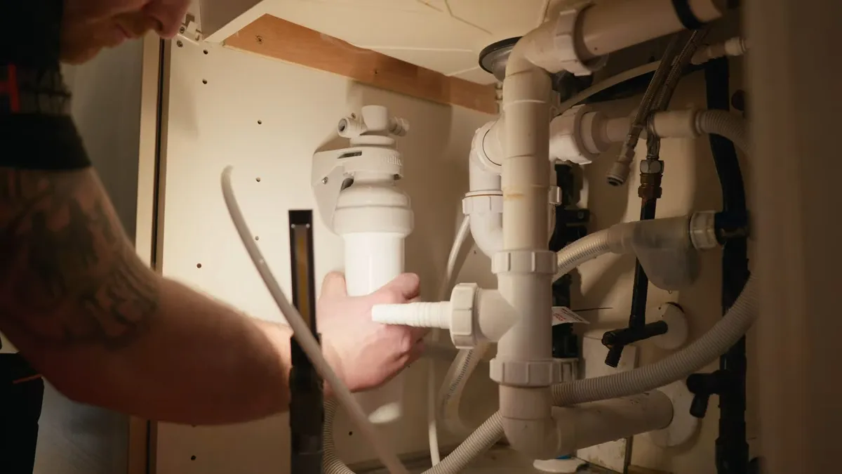 Under-sink filtration canister connected beside the drain and supply lines illustrating spring training rental plumbing prep in surprise, az