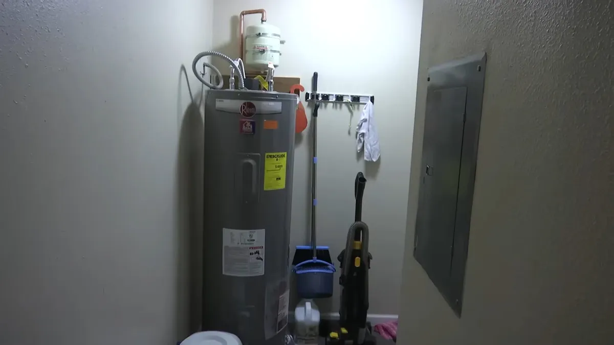 Tank water heater with nearby valves, venting, and supply connections during water heater repair and replacement in surprise, az